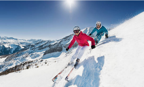 deux personnes descendant une piste à skis