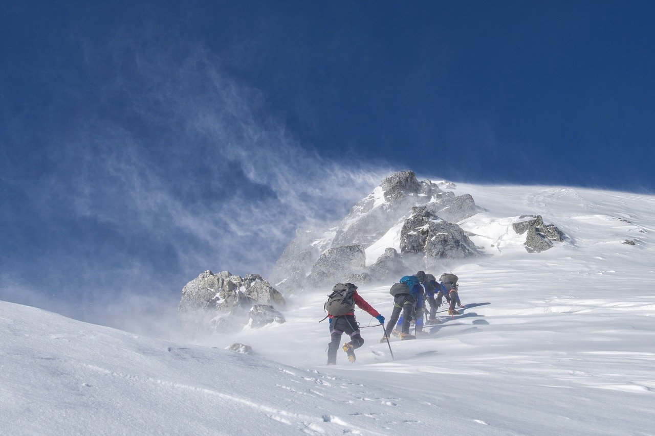 personnes faisant de l'alpinisme dans la neige